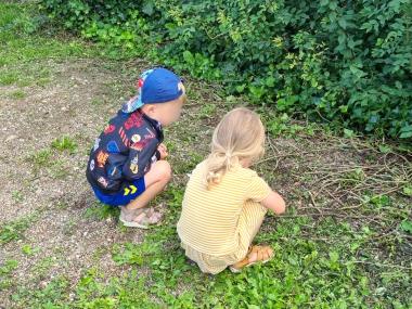 To børn sidder på græsplæne